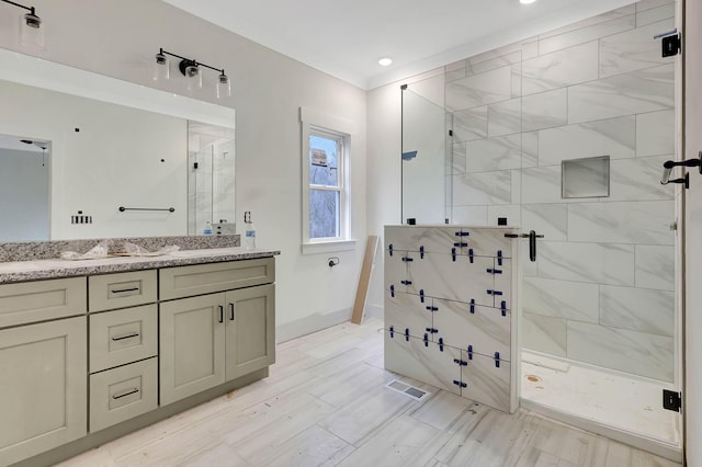 full bathroom featuring visible vents, a shower stall, vanity, and baseboards