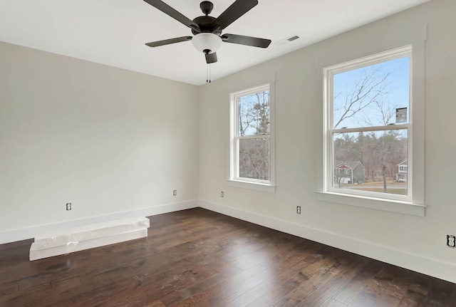 unfurnished room featuring ceiling fan, dark wood-type flooring, and baseboards