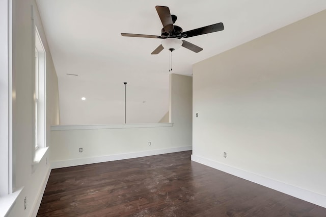 unfurnished room with baseboards, dark wood finished floors, and a ceiling fan