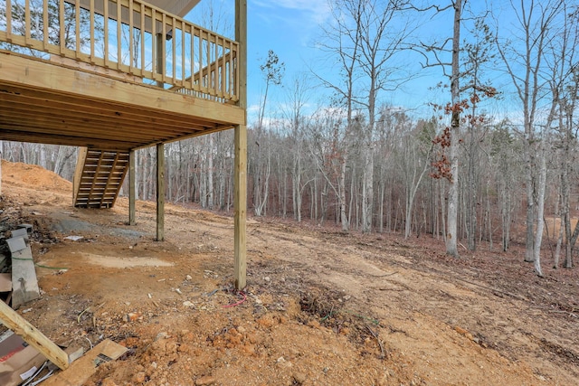 view of yard featuring a forest view and stairs