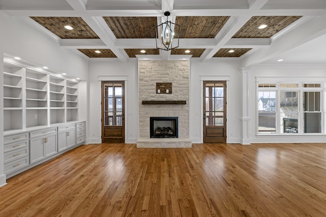 unfurnished living room featuring light wood-type flooring, coffered ceiling, a fireplace, and baseboards