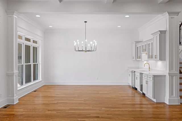 unfurnished dining area featuring light wood finished floors, baseboards, visible vents, and a sink