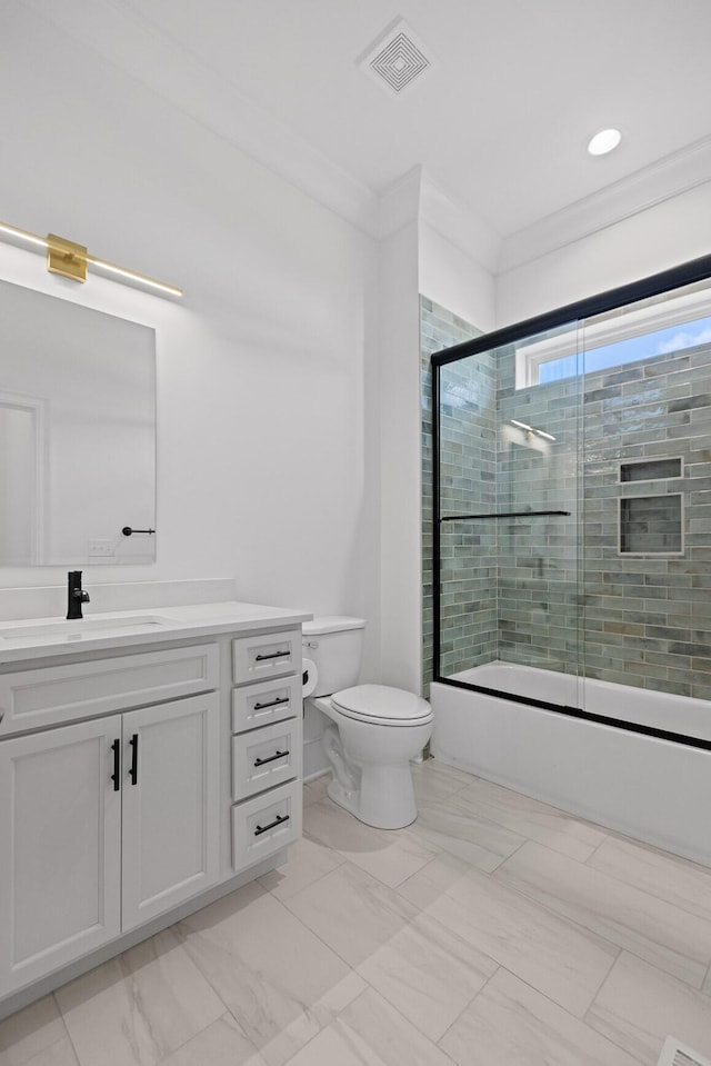 full bathroom featuring toilet, bath / shower combo with glass door, vanity, visible vents, and ornamental molding