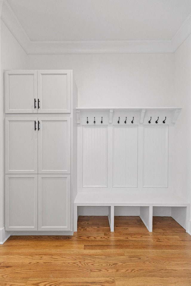 mudroom featuring light wood-style flooring and crown molding