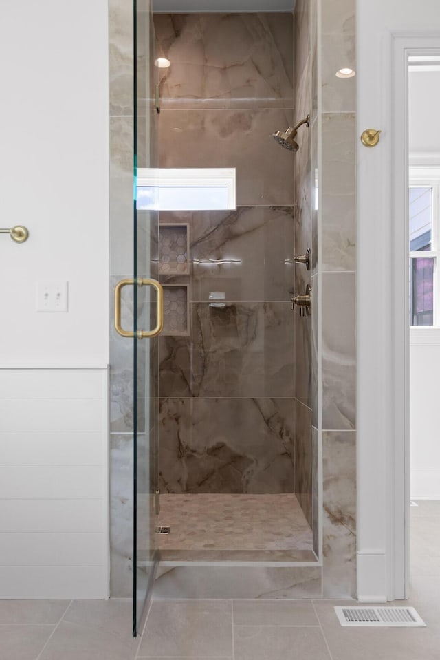 bathroom with a shower stall, visible vents, and tile patterned flooring