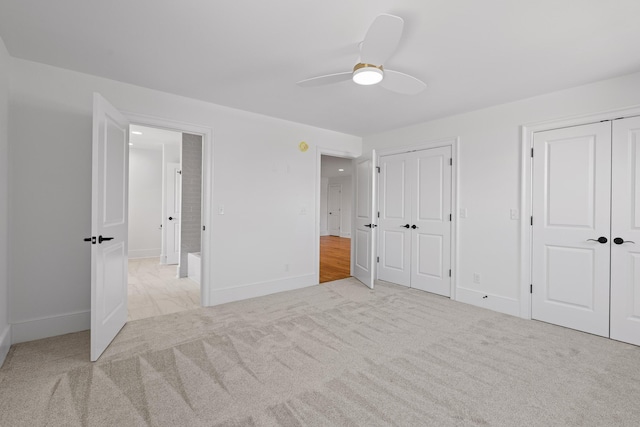 unfurnished bedroom featuring carpet, baseboards, and multiple closets