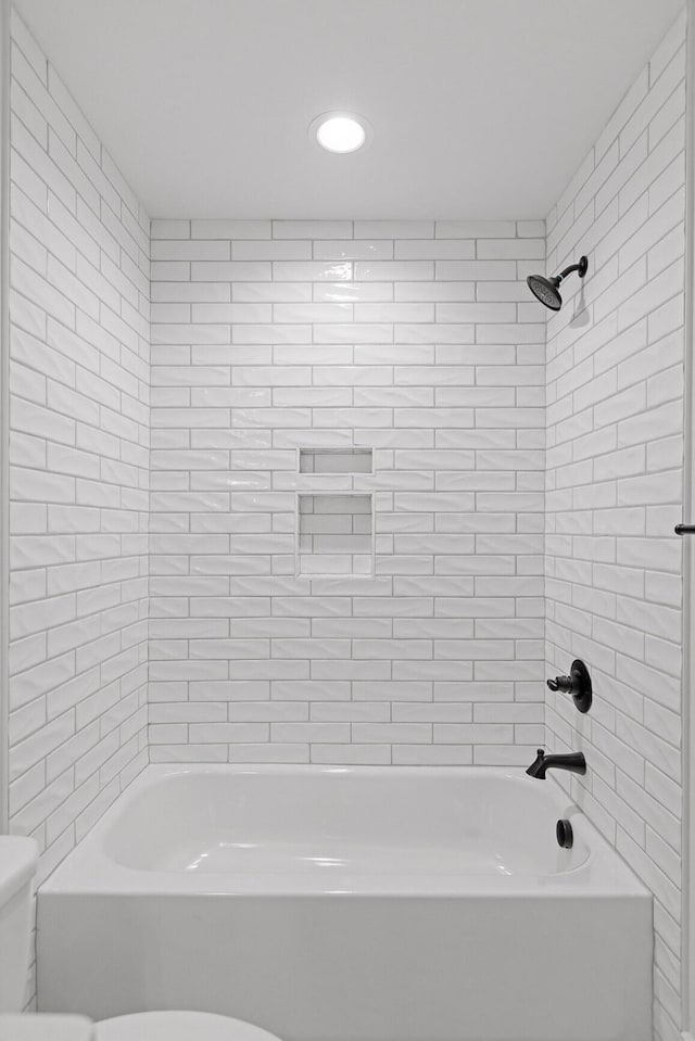 bathroom featuring shower / washtub combination and toilet