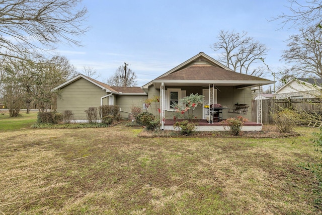 view of front of property featuring a front lawn, a porch, and fence