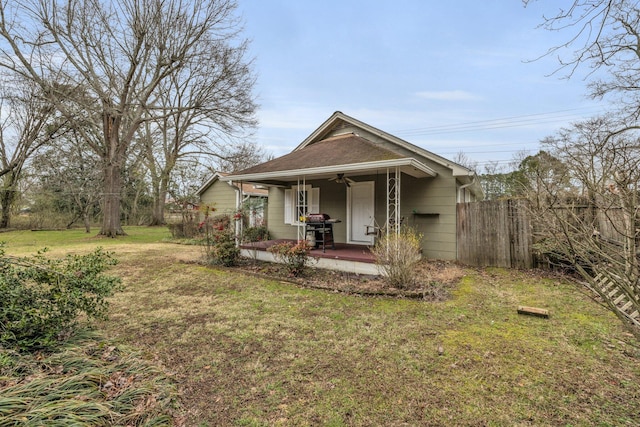 view of front of property with a patio area, a front yard, fence, and a ceiling fan