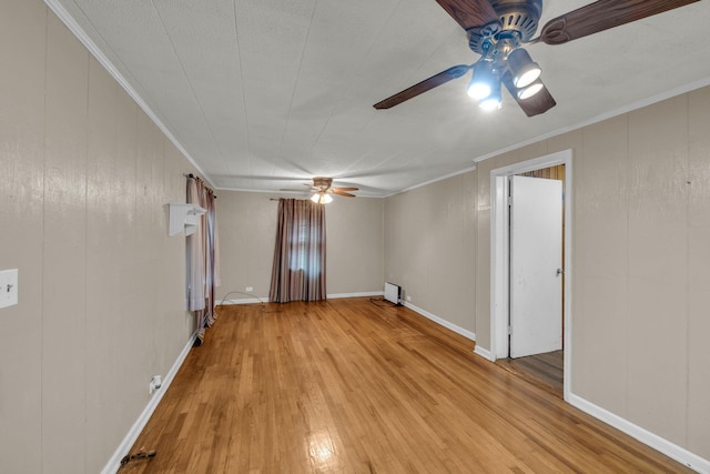 spare room with light wood-type flooring, crown molding, baseboards, and ceiling fan