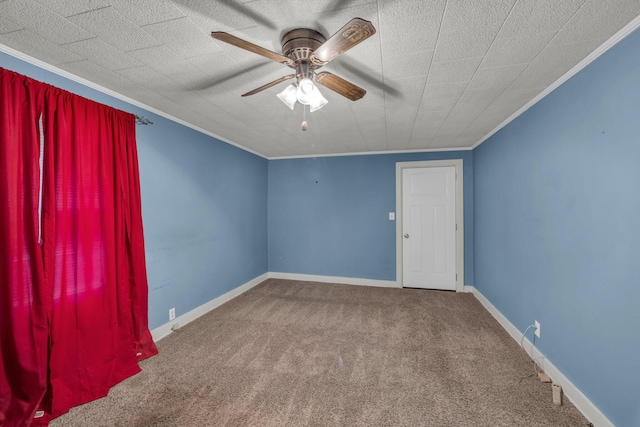 unfurnished room with ornamental molding, carpet flooring, a ceiling fan, and baseboards