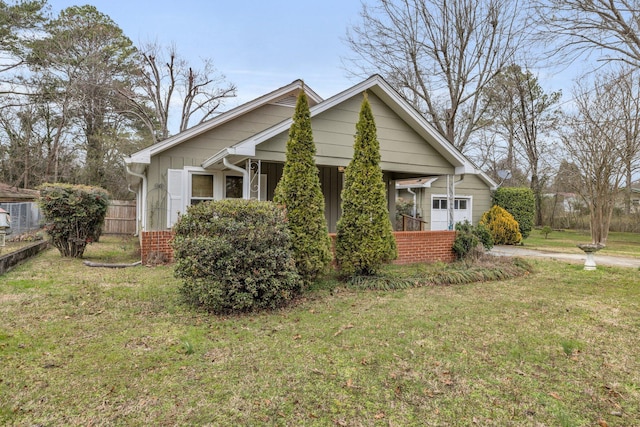 view of front of house featuring fence, a porch, and a front yard