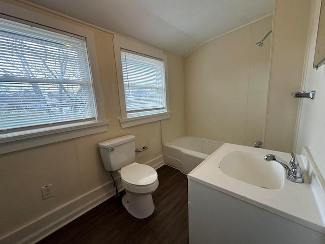 full bathroom featuring a tub to relax in, baseboards, lofted ceiling, toilet, and wood finished floors