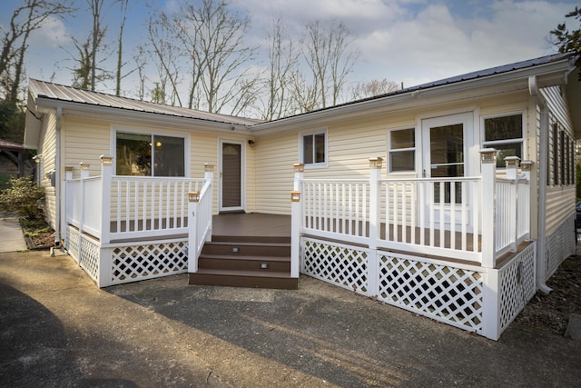 rear view of property featuring metal roof and a deck