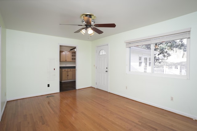 foyer entrance featuring ceiling fan, visible vents, baseboards, and wood finished floors