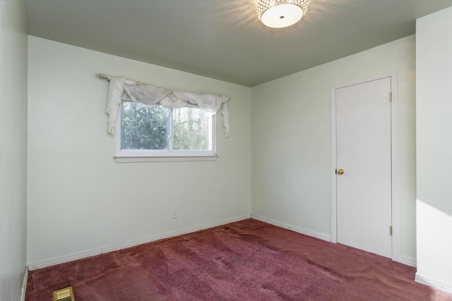 spare room with carpet, visible vents, and baseboards