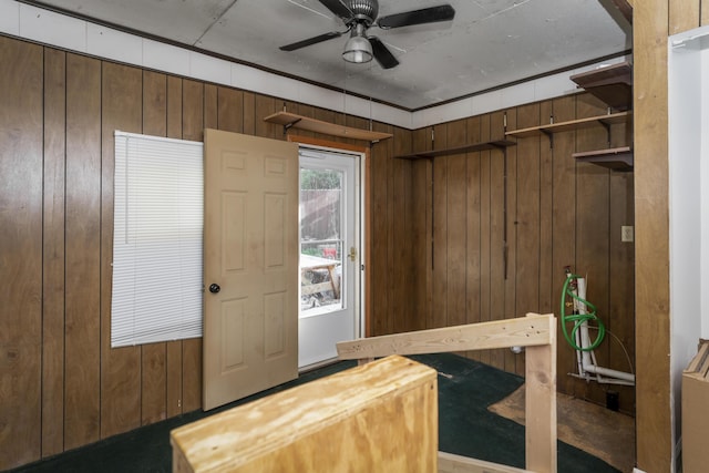 foyer entrance featuring wood walls and a ceiling fan