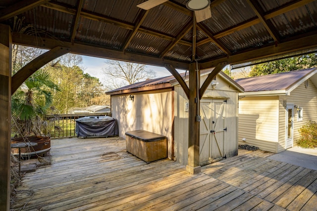 wooden terrace with an outbuilding, a gazebo, and a storage shed