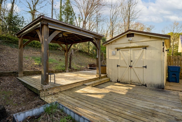 wooden deck featuring an outbuilding, a gazebo, and a storage shed