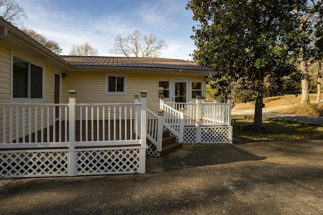 rear view of house with a wooden deck and metal roof