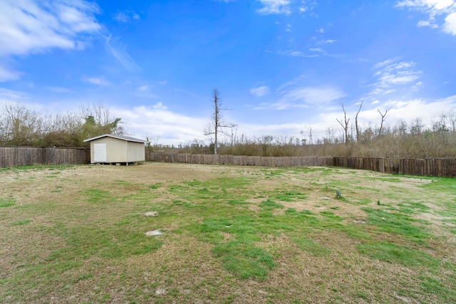 view of yard featuring an outbuilding, a storage unit, and a fenced backyard