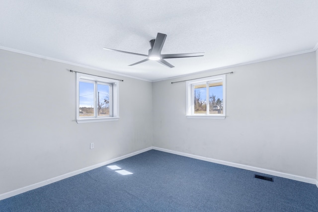 unfurnished room featuring crown molding, a healthy amount of sunlight, visible vents, and carpet floors