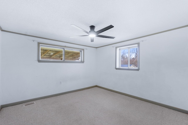 carpeted empty room with plenty of natural light, baseboards, and ornamental molding