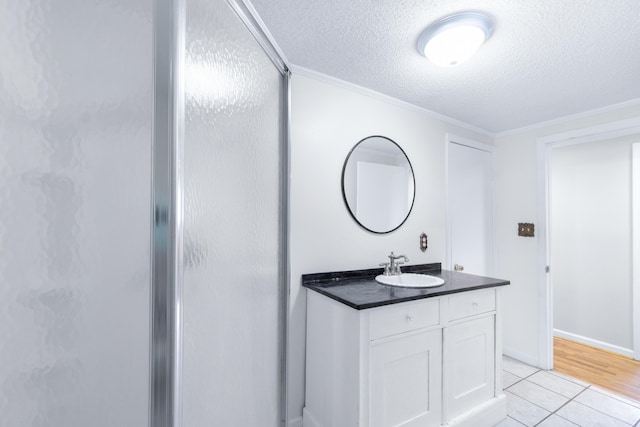 full bath featuring vanity, a stall shower, and a textured ceiling