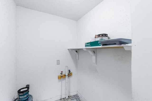 clothes washing area with baseboards