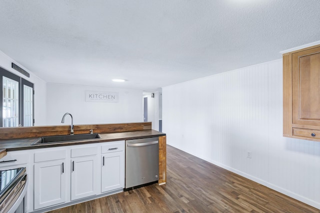 kitchen featuring wooden counters, dark wood finished floors, appliances with stainless steel finishes, white cabinetry, and a sink