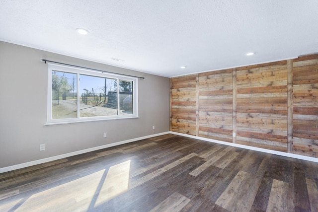 unfurnished room with recessed lighting, baseboards, a textured ceiling, and wood finished floors