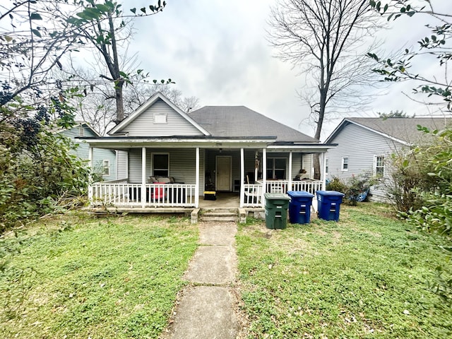 view of front of house featuring a porch, a shingled roof, and a front lawn