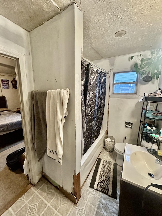 bathroom featuring a textured ceiling, vanity, toilet, and shower / tub combo with curtain