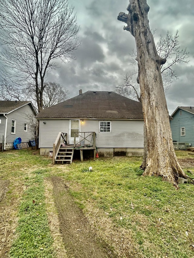 rear view of property featuring a wooden deck and a yard
