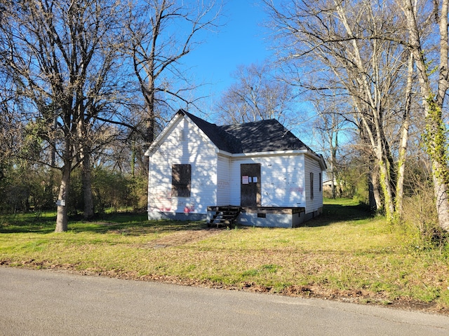 view of property exterior featuring a shingled roof, entry steps, crawl space, and a lawn