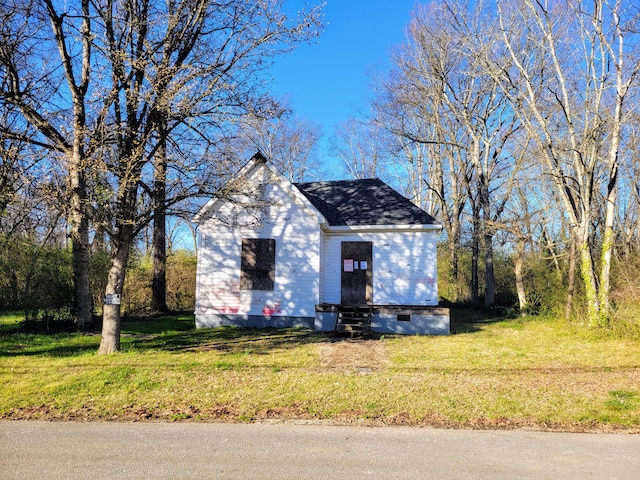 view of front of property with a shingled roof, a front yard, and entry steps