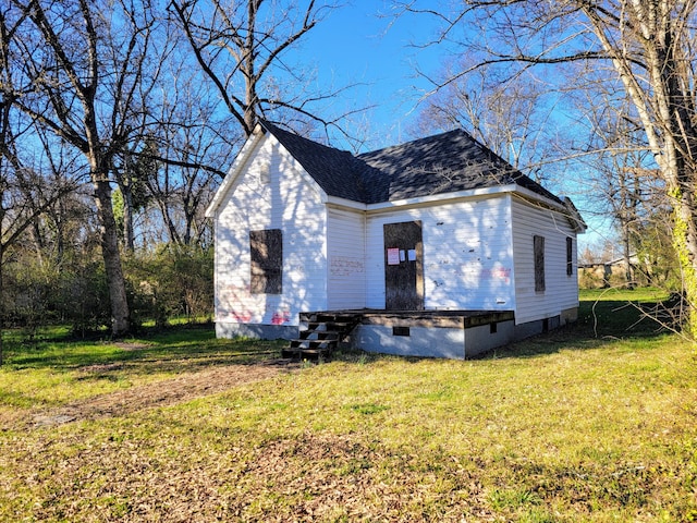 view of side of property featuring crawl space, a shingled roof, and a yard