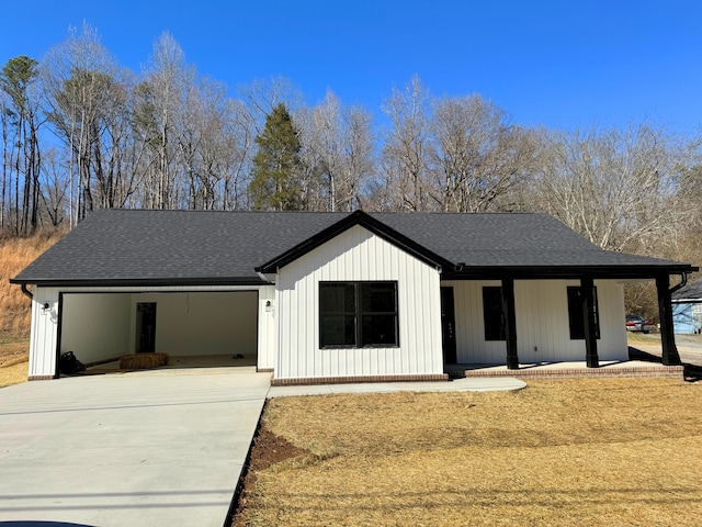 modern farmhouse with a garage, concrete driveway, and a shingled roof