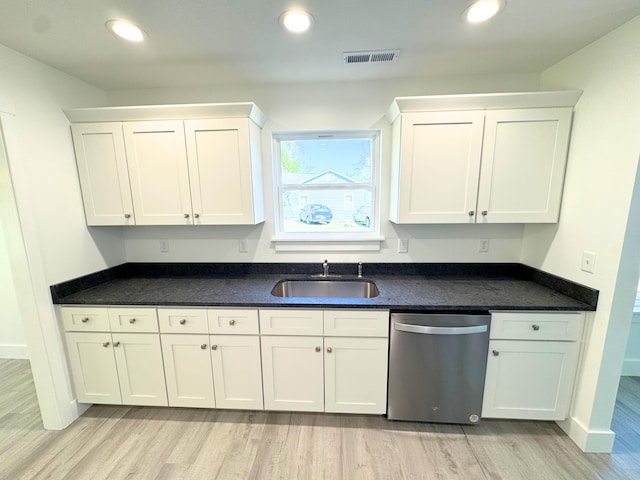 kitchen featuring stainless steel dishwasher, a sink, and white cabinets