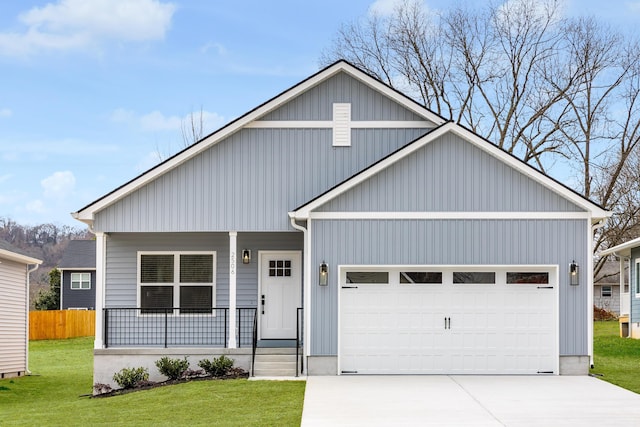 view of front of property with a garage, concrete driveway, covered porch, fence, and a front yard