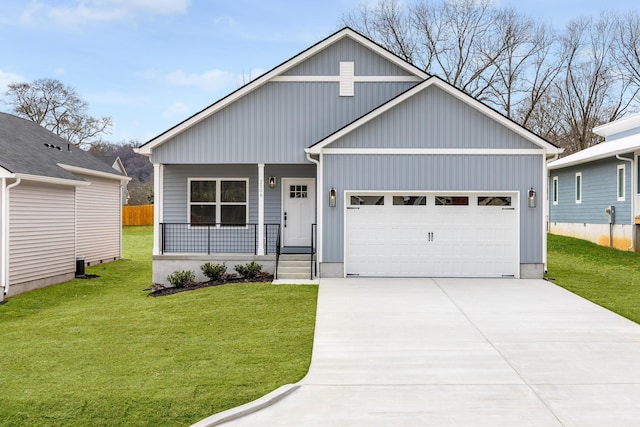 view of front facade with covered porch, fence, a garage, driveway, and a front lawn