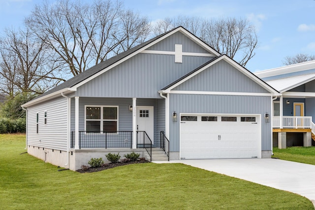 view of front facade with a garage, a front yard, covered porch, and driveway