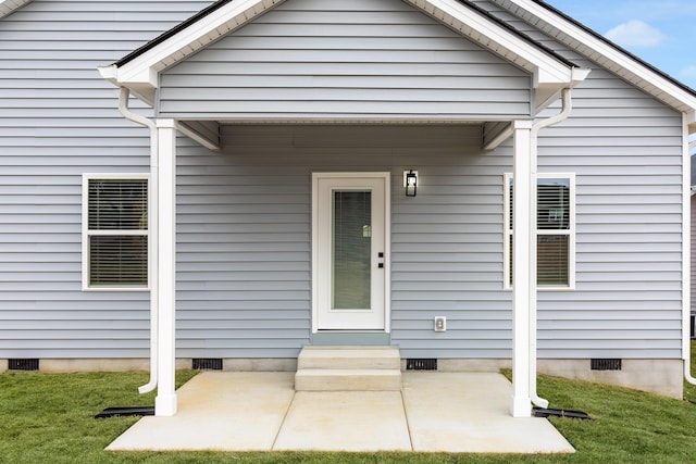 property entrance with crawl space and a lawn