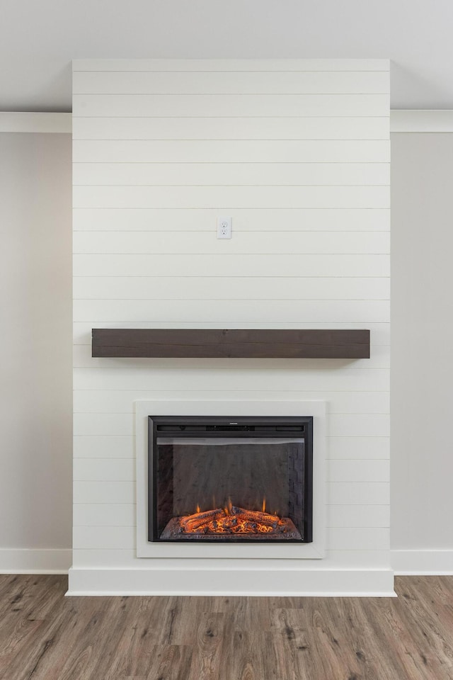 room details with a fireplace, wood finished floors, and baseboards