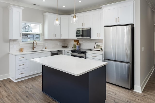 kitchen featuring light wood finished floors, visible vents, stainless steel appliances, light countertops, and a sink