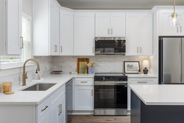 kitchen featuring white cabinets, appliances with stainless steel finishes, backsplash, and a sink