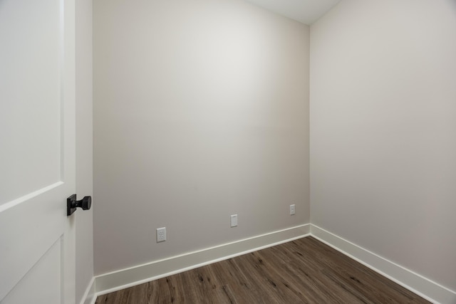 spare room featuring dark wood finished floors and baseboards