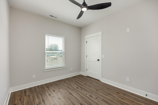 spare room featuring ceiling fan, visible vents, baseboards, and wood finished floors