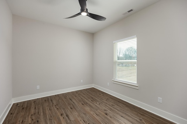 unfurnished room with a ceiling fan, visible vents, baseboards, and dark wood-style flooring