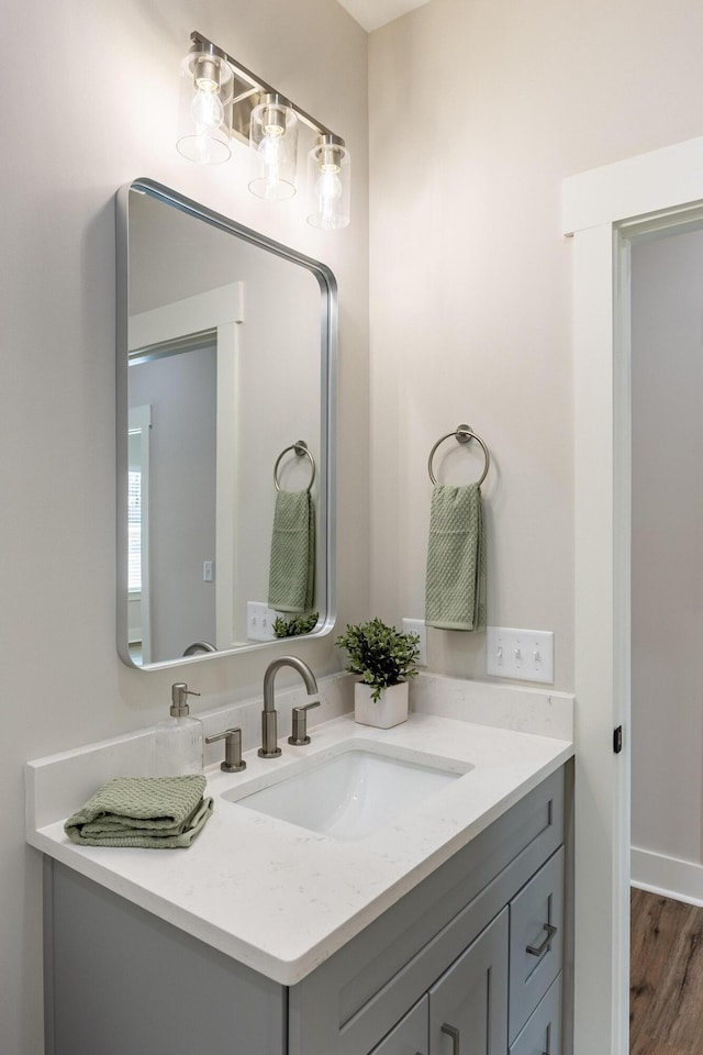 bathroom featuring baseboards, wood finished floors, and vanity